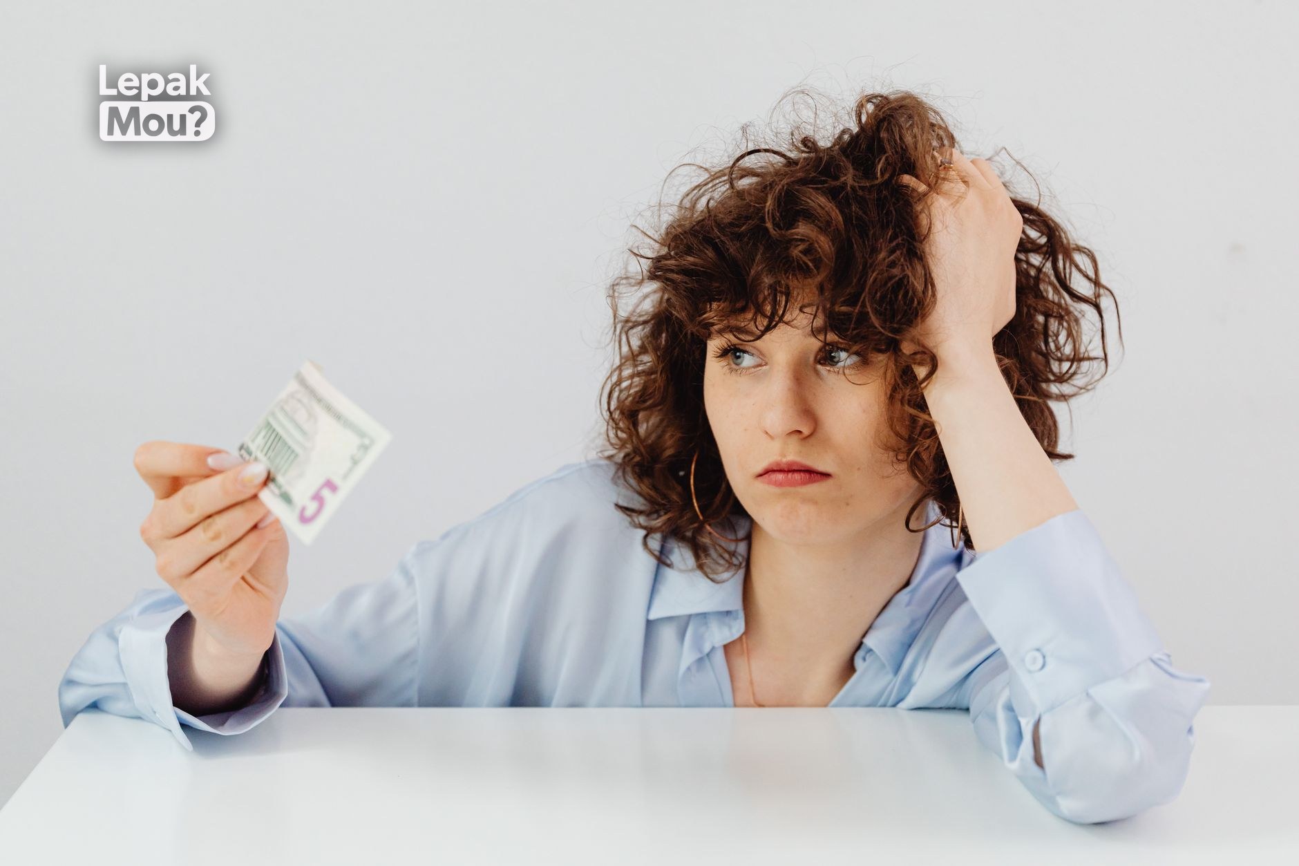 A person feeling stressed while reviewing finances, reflecting the link between money and mental health